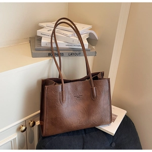 Detail shot of brown PU leather tote bag texture with Fashion Trend WWTU logo