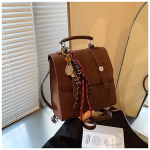 Detail of vintage brown leather backpack with retro metal buckle and tennis racket charm