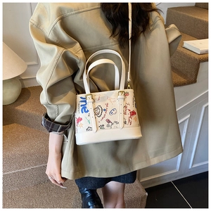 Détail du sac graffiti blanc avec imprimés de dessins animés colorés et boucle en métal