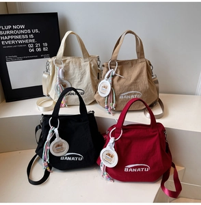Detail of four colorful nylon bucket bags with brand logo and capybara charms