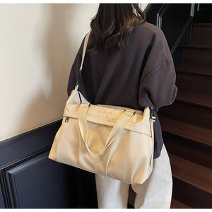 Dettaglio borsa da viaggio in tela beige con ricamo NINGJIA e tasca laterale con zip