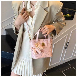 Detaillierte Makroansicht der rosa Cartoon-Beuteltasche mit Golddekor und Plüschanhänger