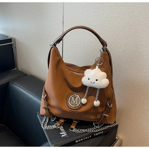 Dettaglio borsa tote in nylon marrone con logo M argento e charm peluche nuvola