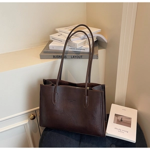 Close-up of deep brown tote bag featuring vintage lychee texture and zipper closure