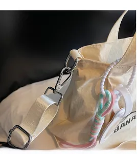 Macro shot of durable metal hook and colorful woven rope on the beige canvas bag