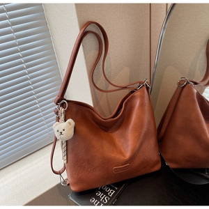Brown leather Hobo bag detail with cream teddy charm and delicate logo plate