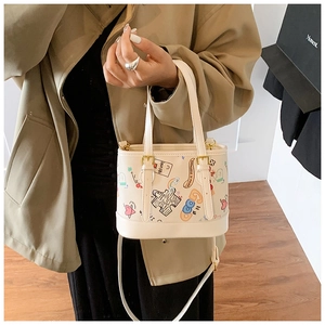 Détail du sac graffiti avec motifs colorés dessinés à la main et boucles dorées