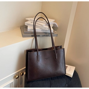 Detail view of large brown vintage tote bag with fashion trend text for office use