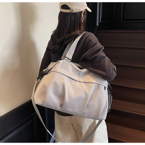 Dettaglio della borsa da viaggio beige chiaro in nylon resistente con manici