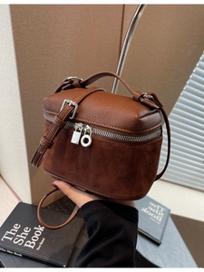 Brown box-shaped crossbody bag featuring textured leather and suede patchwork design