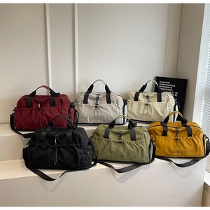 Detailed view of large travel bags in six colors with drawstring pockets and straps
