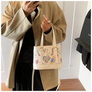 Détail du sac cabas blanc cassé à graffitis avec cœurs colorés et ferrures dorées élégantes