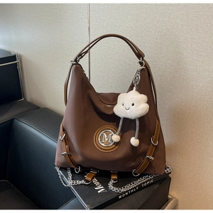 Dettaglio borsa tote marrone scuro con logo M in metallo e charm a forma di nuvola