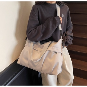 Dettaglio della borsa da viaggio in tela minimalista con logo NIING J su tessuto di pregio