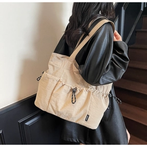 Detail view of khaki large capacity tote bag with drawstring pockets and nylon texture