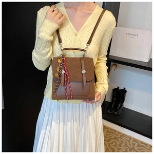 Detail of brown vintage patchwork handbag featuring stylish key charm and woven cord