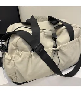 Detail of adjustable black shoulder strap and side drawstring pocket on large travel bag