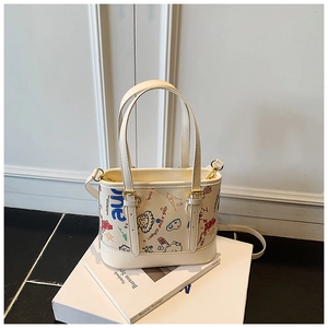 Détail d'un sac seau blanc crème avec graffitis de dessins animés et fine bandoulière