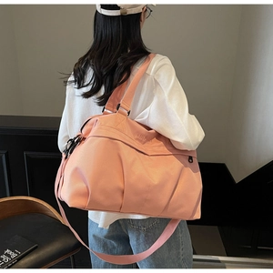 Borsa da viaggio rosa capiente con doppi manici e tracolla regolabile in un interno moderno