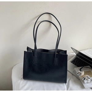 Detail shot of black tote bag featuring vintage wrinkled texture and fashion trend embossing