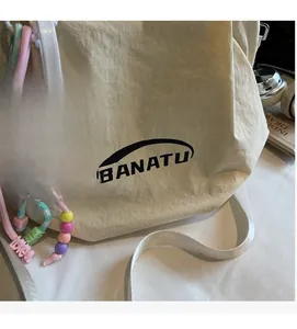 Detail of off-white canvas bag with Banatu logo, Capybara charm and beaded decor