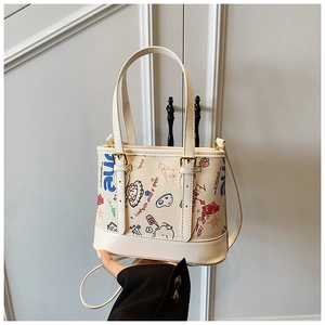 Détail du sac cabas crème avec graffitis colorés et bandoulière réglable pour femmes