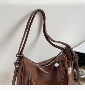 Gros plan du sac vintage marron montrant les bandoulières réglables et fermetures argent