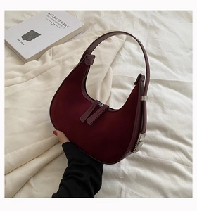 Detailed macro of burgundy suede hobo bag with dual zippers and silver metallic hardware