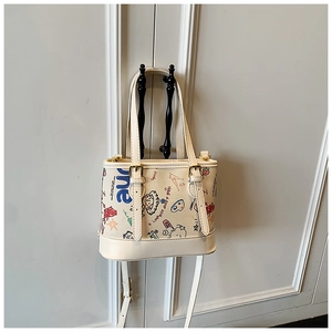 Détail du sac bandoulière en toile crème avec graffitis colorés et motifs d'oursons