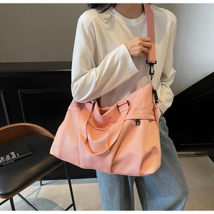 Dettaglio della grande borsa da viaggio rosa in nylon impermeabile con ricamo del logo