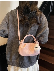 Pink pleated cloud bag with marble texture and plush monster charm worn by model