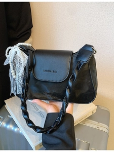 Minimalist black leather underarm bag with pearl lace bow and woven strap detail