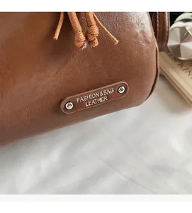 Gros plan sur un sac en cuir marron texturé avec rivet métallique et marquage fashion