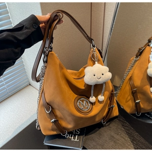 Dettaglio borsa tote in pelle scamosciata color cuoio con finiture e charm peluche