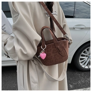 Suede brown leopard print handbag with pink heart charm shown in a street style look