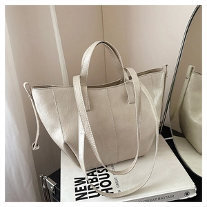Detail of cream white tote bag with pleated oil wax leather texture and drawstring side