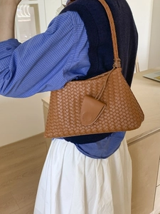 Borsa a secchiello marrone intrecciata con tracolla e ciondolo a triangolo chic