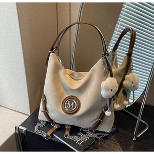 Dettaglio della borsa hobo in pelle scamosciata beige con finiture in cuoio