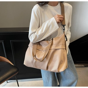Dettaglio del logo NINGJIA ricamato su una borsa da viaggio grande in nylon marrone