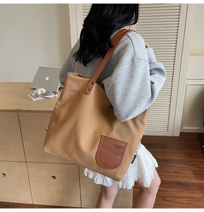 Dettaglio della borsa tote in tela kaki con finiture e tracolle in pelle marrone