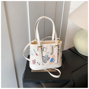 Détail du mini sac cabas en toile blanche avec graffitis et finitions dorées