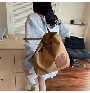 Dettaglio della borsa tote in tela cammello con trama del tessuto e spalline in pelle marrone