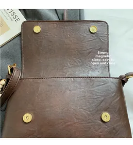 Détail du sac à bandoulière marron vintage avec fermoirs magnétiques dorés puissants