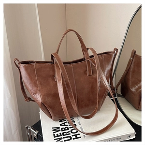 Detailed view of vintage dark brown tote bag with contrast stitching on leather surface
