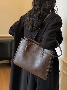Dark brown tote bag in oil-wax finish with leather texture and thin shoulder straps
