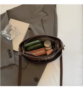 Top-down view of spacious interior in brown leather bucket bag with daily essentials