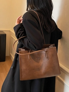 Brown matte leather tote bag with embossed text and long shoulder strap for women