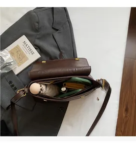 Vue intérieure du sac bandoulière rétro marron montrant un grand espace de rangement