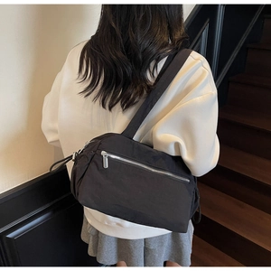 Detailed back view of a minimalist black nylon tote bag worn with casual outfit