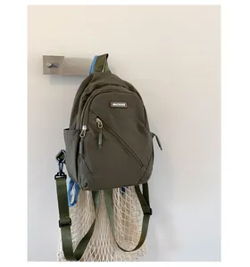 Detail of olive green nylon backpack with Machuge logo label and diagonal zipper pocket